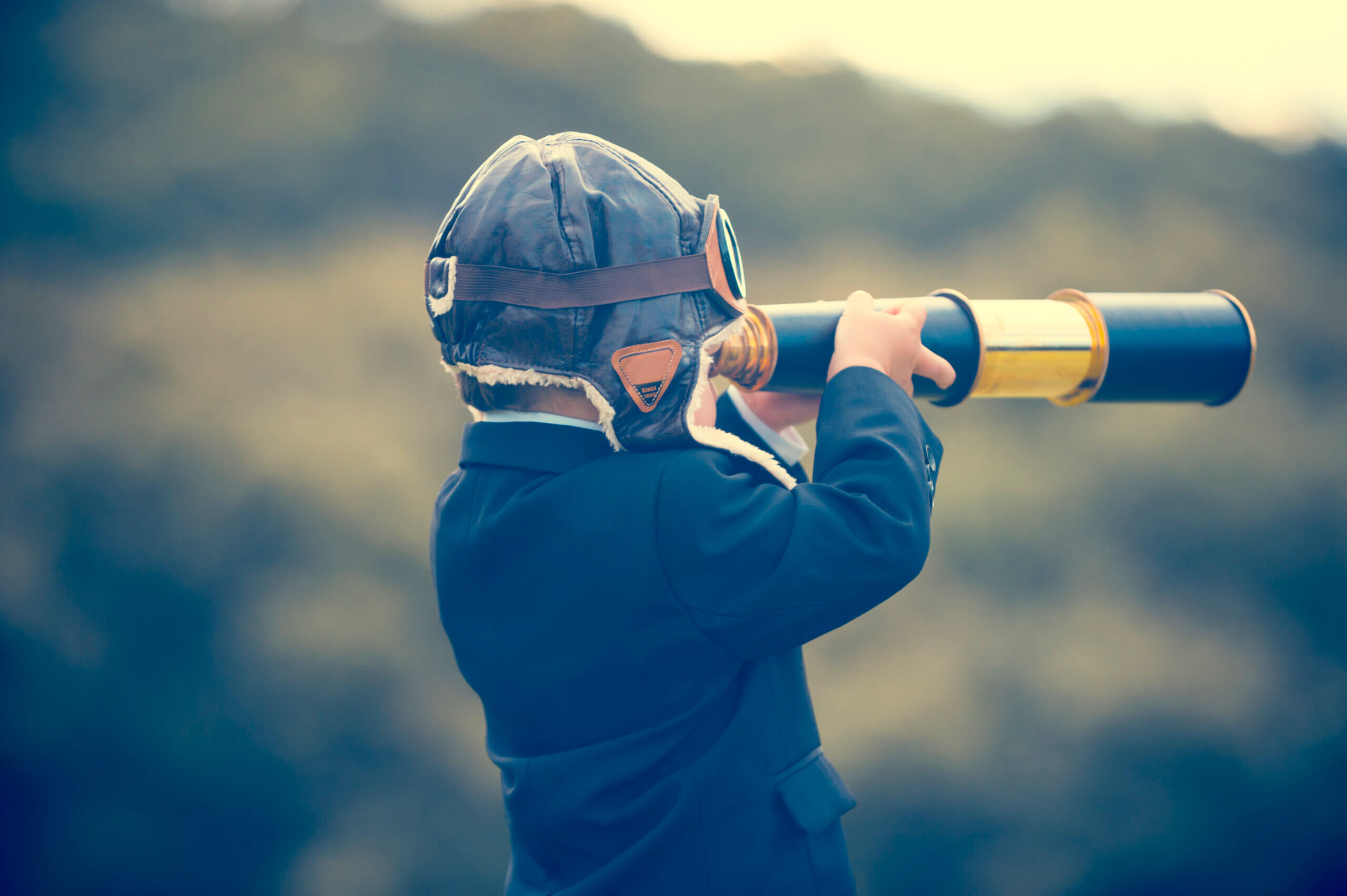 Young boy in a business suit with telescope.